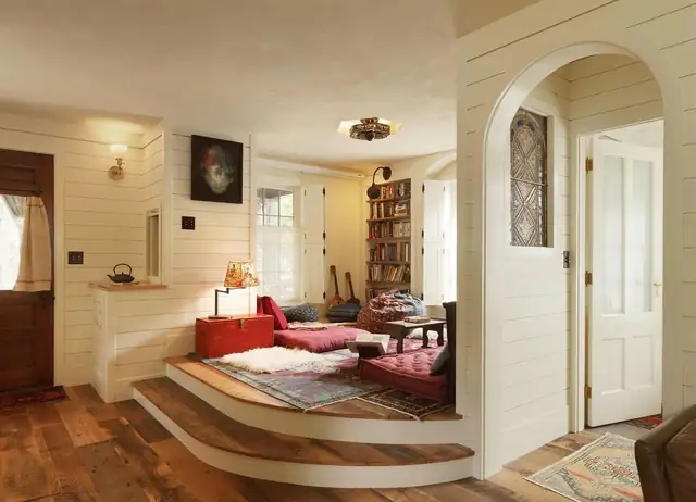 Whole-home remodel of an older house with arched doorway, shiplap walls, raised reading nook and wood floors