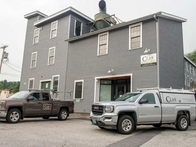Clar Construction shop and office in the gray clapboard National Clothespin Company building, with company trucks out front
